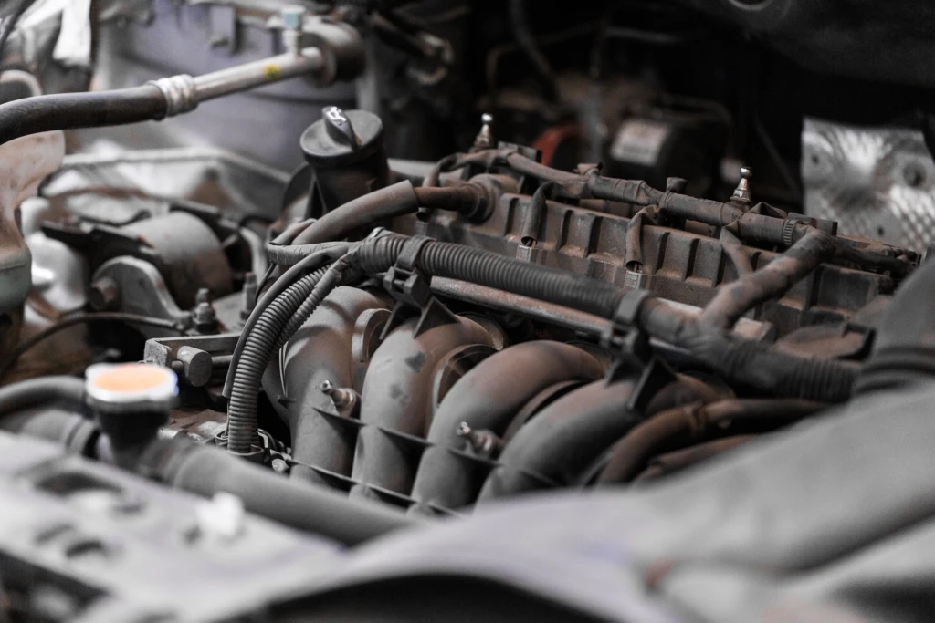 Close-up of a car engine with visible cables and components. The image conveys a technical and mechanical tone, emphasizing automotive detail.